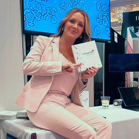 A woman holding a box of ariessence pure PDGF+