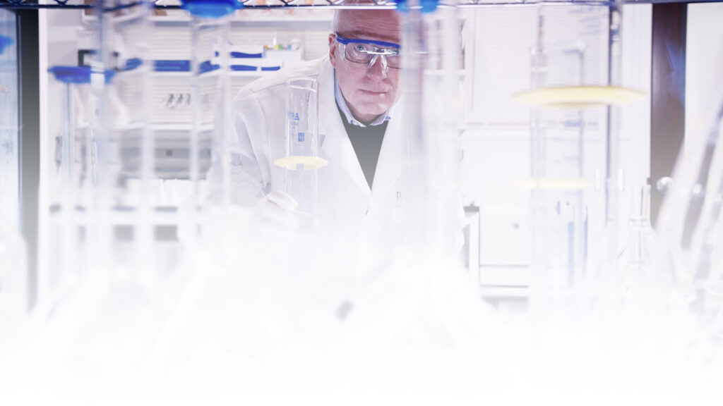 Dr. Lynch working in a laboratory with a variety of beakers and flasks